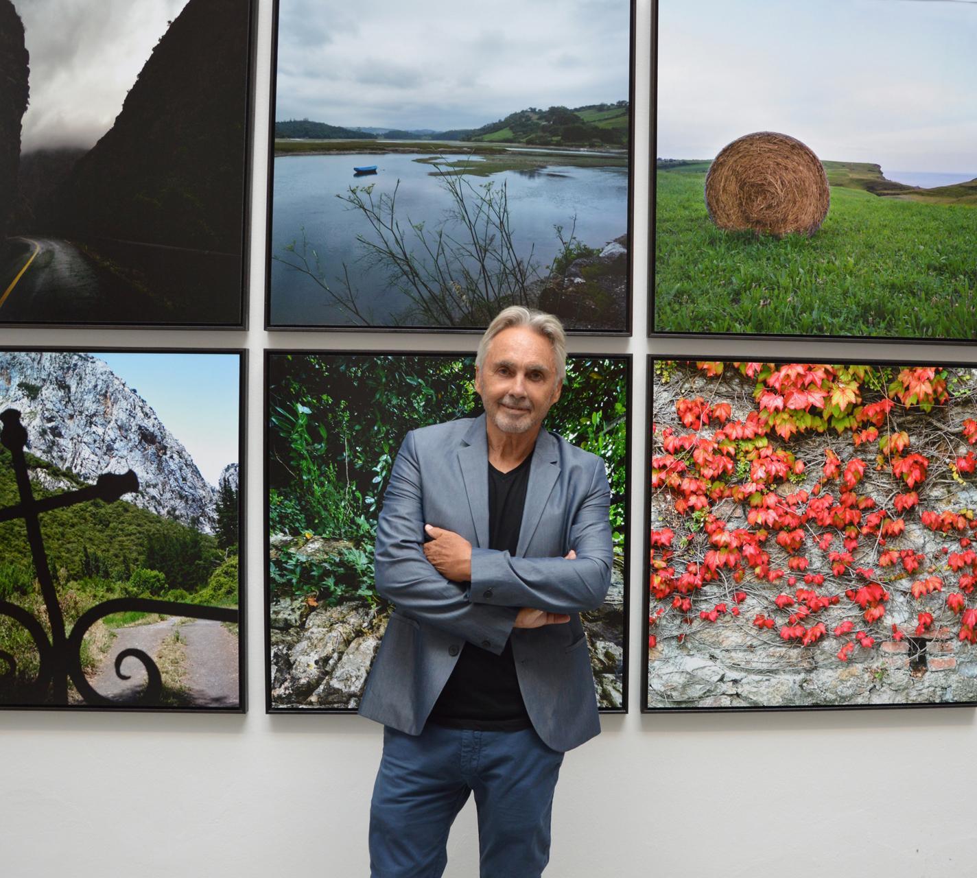 El fotógrafo Ángel Luis Aldai delante de sus fotografías realizadas en Cantabria.