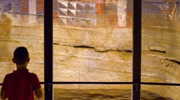 Un niño contempla la cámara decorada de la Cueva Pintada