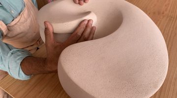 Las manos del creador trabajando una de sus esculturas