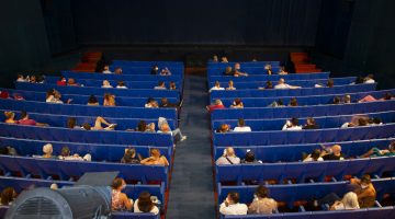 el público espera el inicio de una representación en el cuyás manteniendo distancias