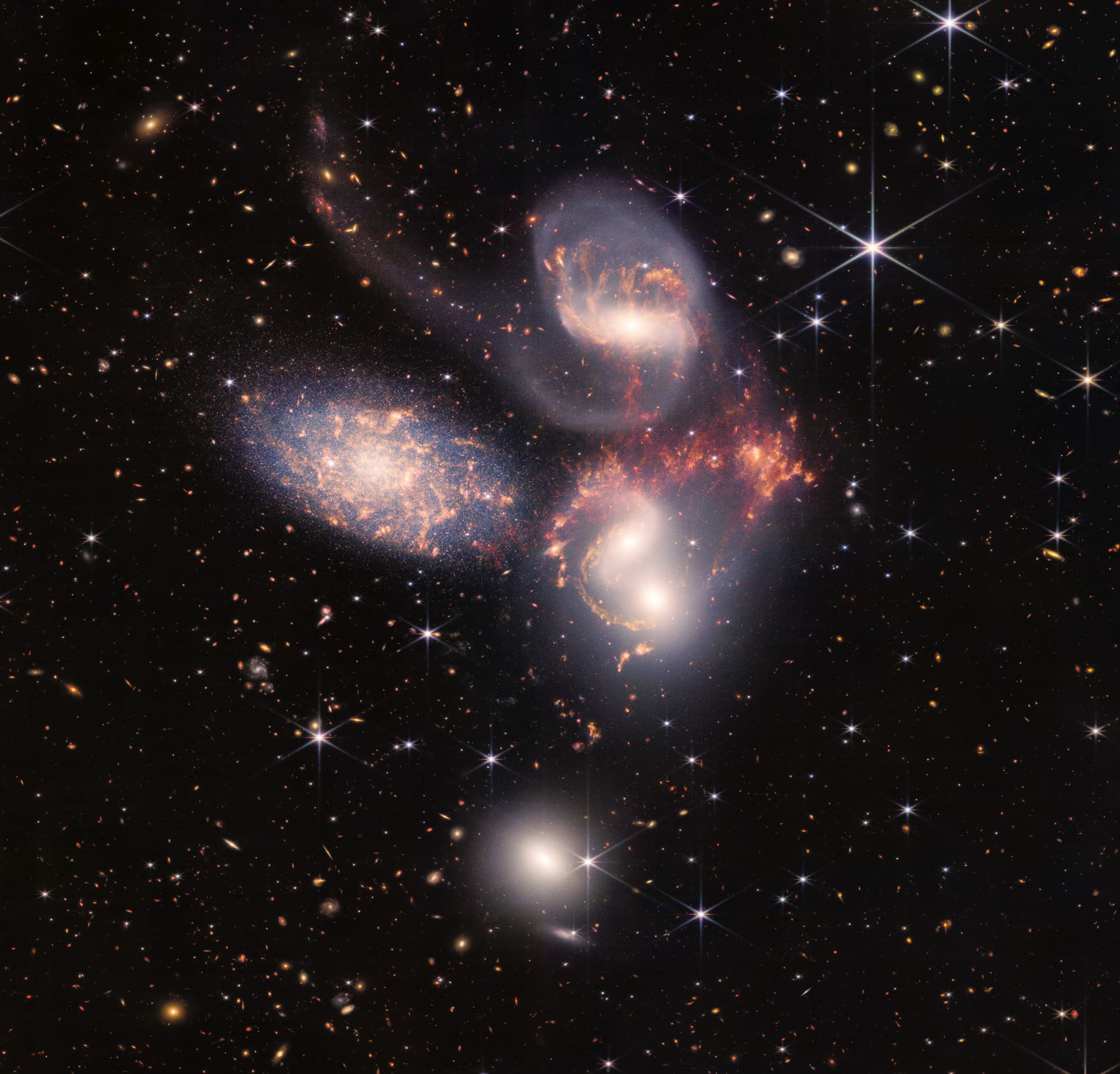 An enormous mosaic of Stephan’s Quintet is the largest image to date from NASA’s James Webb Space Telescope, covering about one-fifth of the Moon’s diameter. It contains over 150 million pixels and is constructed from almost 1,000 separate image files. The visual grouping of five galaxies was captured by Webb’s Near-Infrared Camera (NIRCam) and Mid-Infrared Instrument (MIRI). With its powerful, infrared vision and extremely high spatial resolution, Webb shows never-before-seen details in this galaxy group. Sparkling clusters of millions of young stars and starburst regions of fresh star birth grace the image. Sweeping tails of gas, dust and stars are being pulled from several of the galaxies due to gravitational interactions. Most dramatically, Webb’s MIRI instrument captures huge shock waves as one of the galaxies, NGC 7318B, smashes through the cluster. These regions surrounding the central pair of galaxies are shown in the colors red and gold. This composite NIRCam-MIRI image uses two of the three MIRI filters to best show and differentiate the hot dust and structure within the galaxy. MIRI sees a distinct difference in color between the dust in the galaxies versus the shock waves between the interacting galaxies. The image processing specialists at the Space Telescope Science Institute in Baltimore opted to highlight that difference by giving MIRI data the distinct yellow and orange colors, in contrast to the blue and white colors assigned to stars at NIRCam’s wavelengths.  Together, the five galaxies of Stephan’s Quintet are also known as the Hickson Compact Group 92 (HCG 92). Although called a “quintet,” only four of the galaxies are truly close together and caught up in a cosmic dance. The fifth and leftmost galaxy, called NGC 7320, is well in the foreground compared with the other four. NGC 7320 resides 40 million light-years from Earth, while the other four galaxies (NGC 7317, NGC 7318A, NGC 7318B, and NGC 7319) are about 290 million light-years away. This is still fairly close in cosmic terms, compared with more distant galaxies billions of light-years away. Studying these relatively nearby galaxies helps scientists better understand structures seen in a much more distant universe. This proximity provides astronomers a ringside seat for witnessing the merging of and interactions between galaxies that are so crucial to all of galaxy evolution. Rarely do scientists see in so much exquisite detail how interacting galaxies trigger star formation in each other, and how the gas in these galaxies is being disturbed. Stephan’s Quintet is a fantastic “laboratory” for studying these processes fundamental to all galaxies. Tight groups like this may have been more common in the early universe when their superheated, infalling material may have fueled very energetic black holes called quasars. Even today, the topmost galaxy in the group – NGC 7319 – harbors an active galactic nucleus, a supermassive black hole that is actively accreting material. In NGC 7320, the leftmost and closest galaxy in the visual grouping, NIRCam was remarkably able to resolve individual stars and even the galaxy’s bright core. Old, dying stars that are producing dust clearly stand out as red points with NIRCam. The new information from Webb provides invaluable insights into how galactic interactions may have driven galaxy evolution in the early universe. As a bonus, NIRCam and MIRI revealed a vast sea of many thousands of distant background galaxies reminiscent of Hubble’s Deep Fields. NIRCam was built by a team at the University of Arizona and Lockheed Martin’s Advanced Technology Center. MIRI was contributed by ESA and NASA, with the instrument designed and built by a consortium of nationally funded European Institutes (The MIRI European Consortium) in partnership with JPL and the University of Arizona. For a full array of Webb’s first images and spectra, including downloadable files, please visit: https://webbtelescope.org/news/first-images